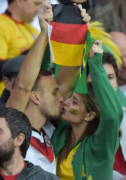 Baci senza frontiere tra un tedesco e una brasiliana. Afp